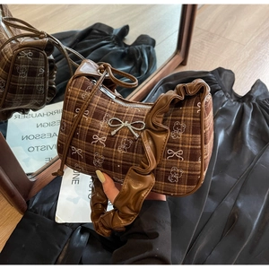 Close-up of brown plaid hobo bag featuring teddy bear prints and cloud-shaped leather strap