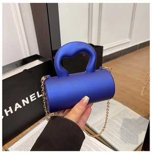 Détail du petit sac cylindrique en acrylique bleu marine avec chaîne dorée