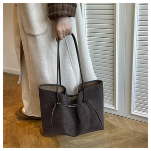 Detail of vintage brown tote bag with matte texture and drawstring side knots