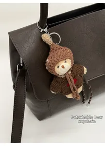 Dettaglio di un ciondolo a forma di orso in maglia rimovibile su una borsa di pelle