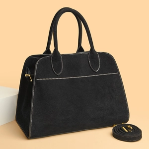 Detail of black frosted tote bag with white contrast stitching and gold hardware