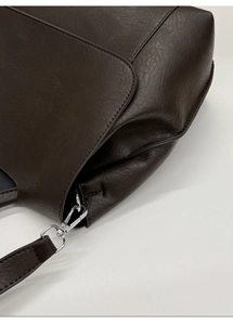 Dettaglio della borsa tote marrone scuro in ecopelle con grana fine e fibbia argento