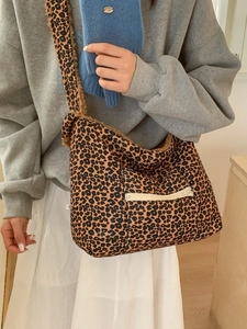 Large leopard print plush crossbody bag with wide shoulder strap and front zipper pocket