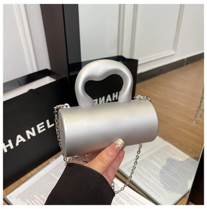 Détail du mini sac cylindre argenté avec poignée métallique élégante et bandoulière