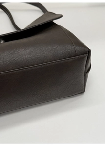 Dettaglio ravvicinato della borsa tote in pelle marrone scuro con cuciture fini e base tonda