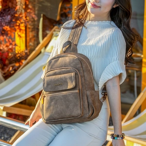 Close-up of vintage brown leather texture and bronze metal hardware on a backpack