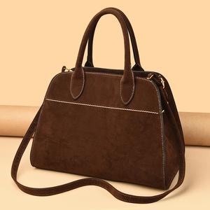 Deep brown matte tote bag featuring white contrast stitching and gold metal hardware
