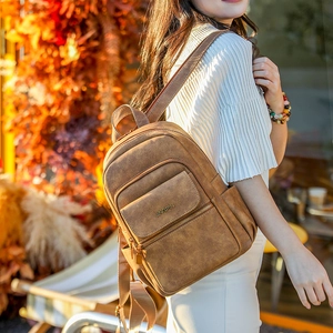 Close-up of vintage brown leather backpack texture and jingpin logo in autumn setting