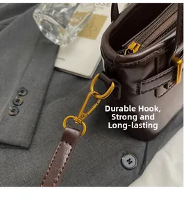 Detail of dark brown bucket bag with lychee grain texture and vintage gold swivel hooks