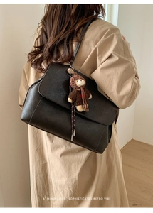 Dettaglio di una borsa tote nera retrò con un ciondolo a forma di orso in maglia