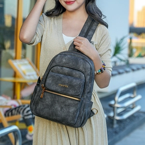 Detail view of a vintage dark grey frosted faux leather backpack with metallic zippers