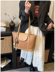 Brown leather tote bag featuring a snap button flap closure and cute bear pendant charm