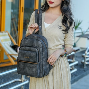 Detail view of washed vintage grey backpack with bronze zippers and layered compartments