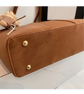Dettaglio del fondo della borsa tote marrone vintage con piedini in metallo dorato e pelle