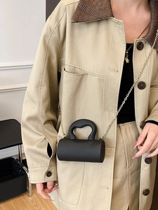 Mini sac cylindrique noir chic avec chaîne dorée et poignée incurvée élégante