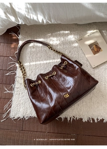 Detailansicht der gesteppten dunkelbraunen Lackleder-Tote Bag mit goldener Kette