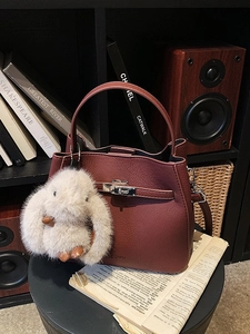 Retro burgundy leather bucket bag with plush bunny charm and golden buckle hardware