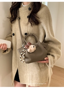 Brown lychee grain leather bucket bag featuring a cute bear charm and beaded strap detail