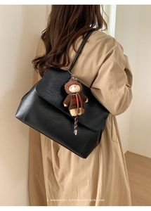 Borsa tote nera in ecopelle con ciondolo a forma di orso indossata da una modella