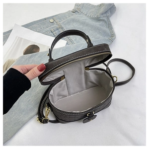 Detailansicht der Kroko-Eimer-Tasche mit goldenem Reißverschluss und geräumigem Innenfutter