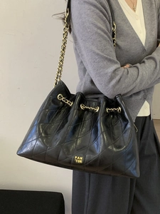 Schwarze Steppleder-Beuteltasche mit goldener Kette und Kordelzugverschluss