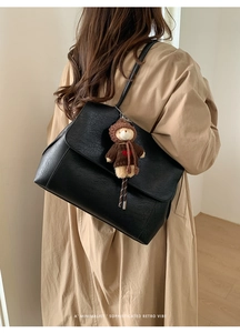 Borsa tote retrò in pelle nera con orsetto di peluche indossata da modella in trench