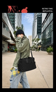 Uomo con una grande borsa da viaggio nera in nylon con tracolla in un contesto urbano