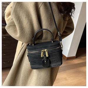 Details der schwarzen Vintage-Vanity-Tasche mit Kroko-Prägung und goldenen Metallelementen