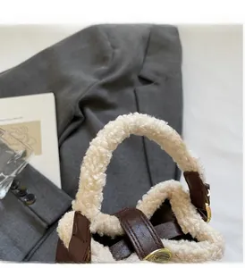 Détail en peluche de laine d'agneau et cuir marron sur un mini sac seau d'hiver