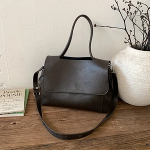 Dettaglio borsa tote vintage marrone scuro con trama in pelle e fibbie argentate