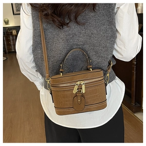 Rear view of brown crocodile texture bucket bag worn with a casual vest and shirt