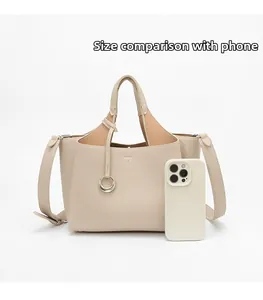 Beige bucket bag with lychee texture leather shown next to a phone for size comparison