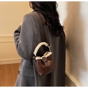 Vue détaillée d'un sac seau en cuir marron avec bordure en polaire porté par un mannequin