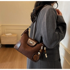 Brown retro shoulder bag with matte suede texture and decorative beaded tassel charm