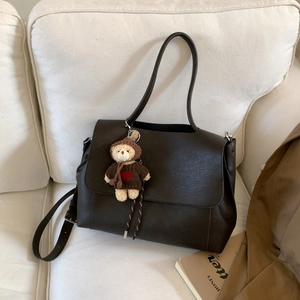 Dettaglio della borsa tote retrò in pelle PU marrone scuro con ciondolo a forma di orsetto