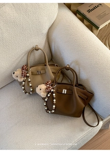 Detail of vintage bucket bags featuring lychee grain leather and beaded pearl handles