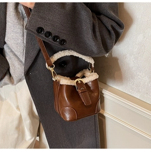 Détail du sac seau en cuir marron avec garniture en fausse fourrure sur un mannequin