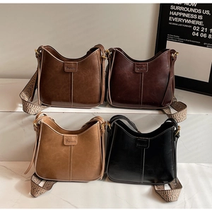 Detail view of four vintage leather bucket bags featuring woven straps in various colors