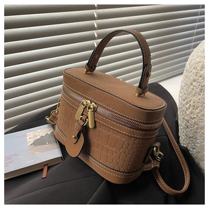 Detail of vintage brown bucket bag with croc-embossed texture and gold-tone zippers