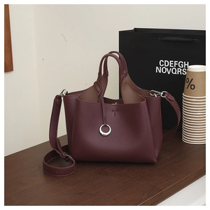Macro shot of dark wine red litchi grain leather bucket bag with silver metal ring buckle