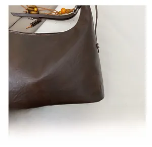 Détail du sac cabas marron foncé avec bandoulière en perles de bois et zip métallique
