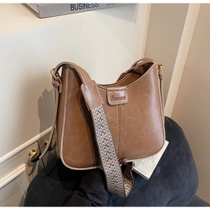 Close-up of brown vintage bucket bag with textured leather and geometric woven strap
