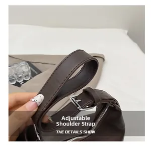 Détail du sac cabas en cuir marron foncé avec bandoulière réglable et boucle argentée