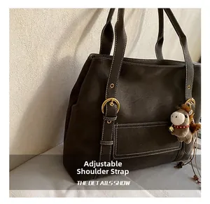 Détail de la bandoulière réglable avec boucle dorée et surpiqûres sur le sac cabas