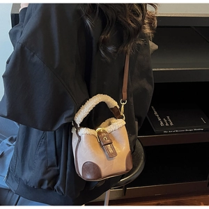 Détail du mini sac seau avec bordure en peau lainée et lanières en cuir marron