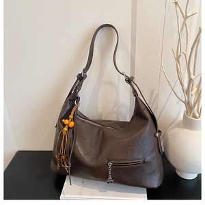 Détail du grand sac cabas marron foncé avec pompon en perles orange et poche zippée