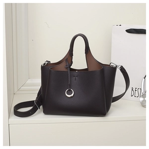 Deep brown lychee pattern leather tote bag with silver ring detail on white shelf