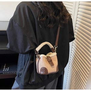Vue détaillée d'un sac seau beige avec poignée en sherpa sur un mannequin femme