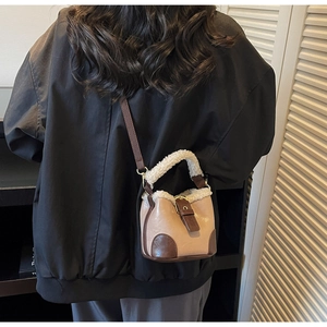 Détail d'un sac seau d'hiver avec bordure en fausse fourrure et bandoulière en cuir