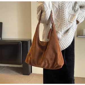 Detail showing high-quality brown suede texture and premium leather strap of the tote bag